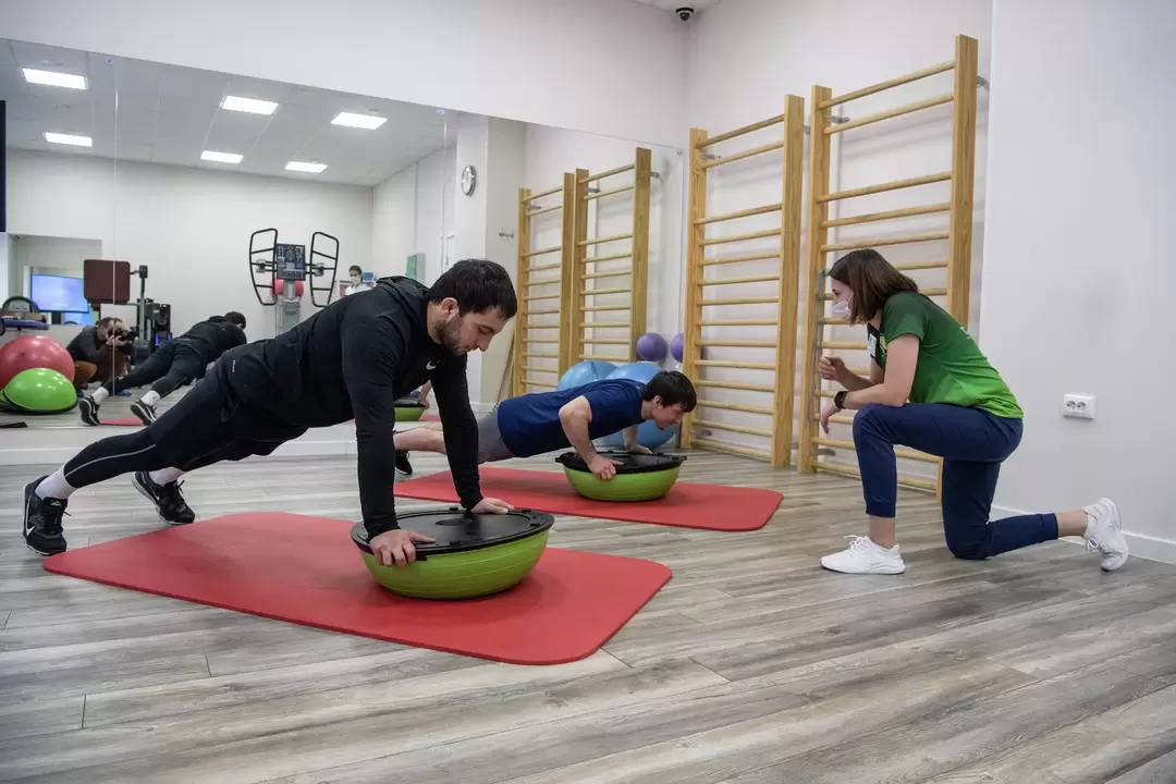 A rehabilitation therapist conducts exercise therapy classes with patients suffering from back pain